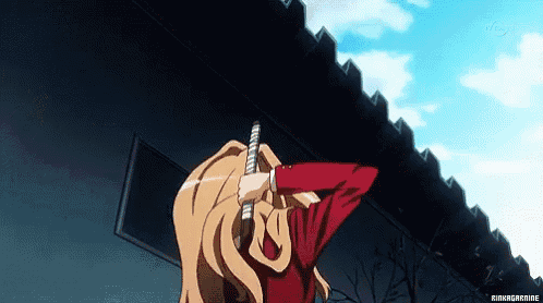 a girl in a red shirt is holding a sword in front of her face .