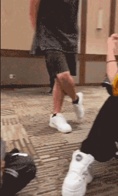 a person wearing a black shirt and white sneakers is dancing