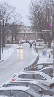 a row of cars are parked on the side of a snow covered road
