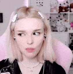 a girl with blonde hair is wearing headphones and a necklace .