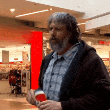 a man in a plaid shirt is standing in front of a store with a sign that says columbia