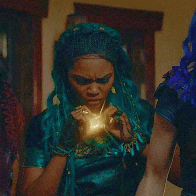 a woman with blue hair is holding a heart shaped necklace