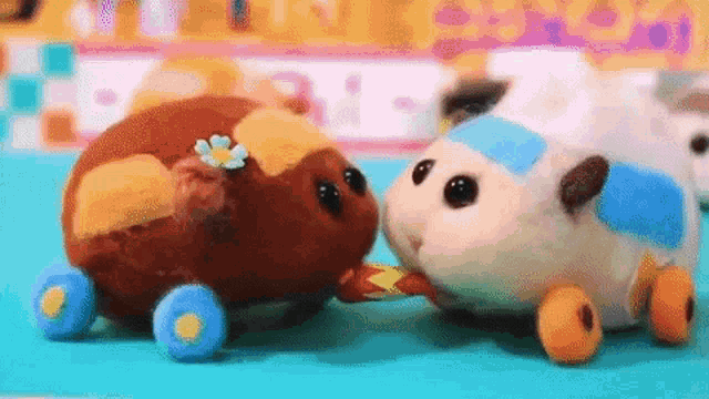 a couple of stuffed animals are standing next to each other on a table .