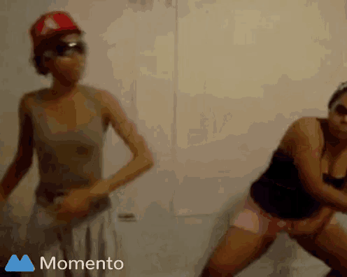 two women are dancing in front of a white wall and the words momento are on the bottom right