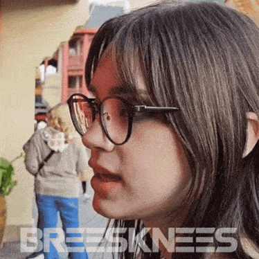 a close up of a woman wearing glasses with the word breeskinnees written on the bottom