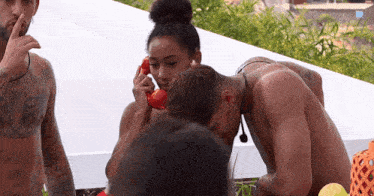 a man and a woman talking on a red telephone