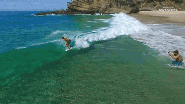 an aerial view of a surfer on a wave with the words awesome on the bottom right