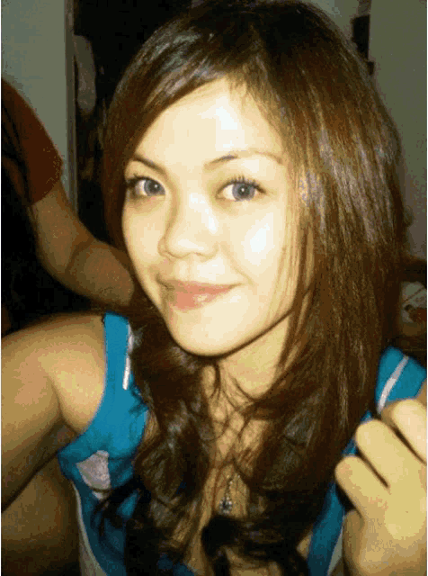 a woman with long hair and a blue shirt is smiling