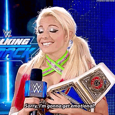 a woman is holding a wrestling championship belt in front of a microphone .
