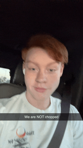 a young man in a car with a snapchat caption that says we are not chopped