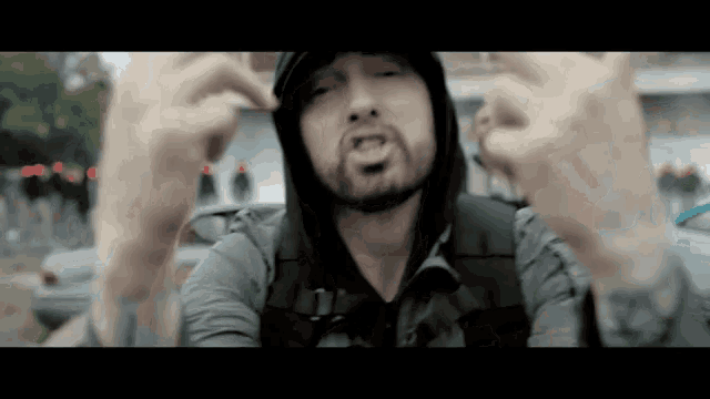 a man wearing a hooded jacket is making a funny face