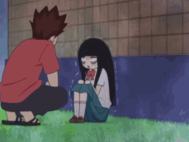a man kneeling down next to a girl who is sitting on the grass