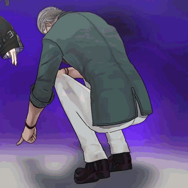 a man in a green jacket is squatting down and pointing