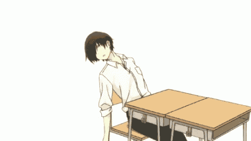 a boy is laying on a desk with his head on the desk .
