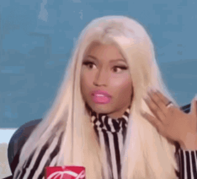 a woman with blonde hair and pink lipstick is holding a coca cola can .