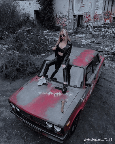 a woman is standing on the hood of a car that says barbie