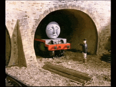 a cartoon train with a sad face is going through a tunnel