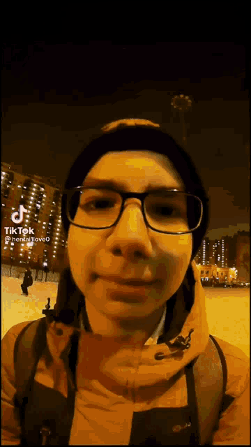 a young man wearing glasses and a beanie looks at the camera with a tiktok watermark in the corner
