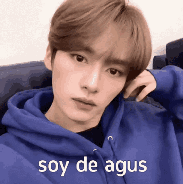a young man wearing a blue hoodie with the words soy de agus written on the bottom