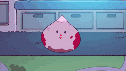 a pink and red cartoon character is sitting on the ground in front of a counter
