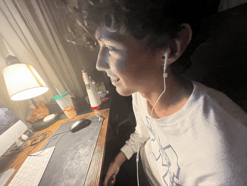 a man wearing ear buds is sitting at a desk
