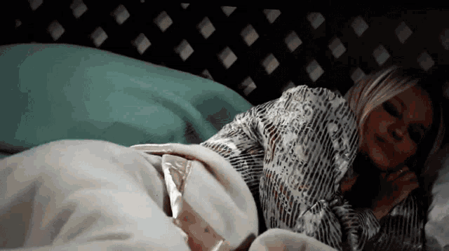 a woman is laying on a bed with a striped shirt on