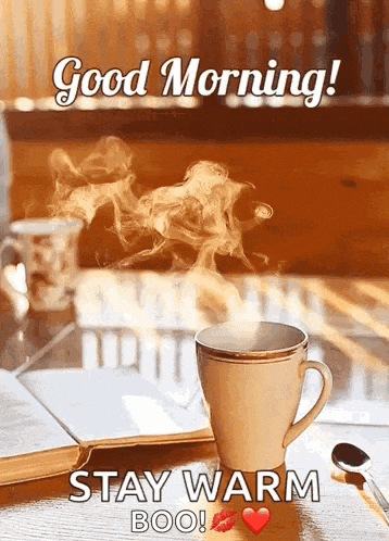a cup of coffee is on a table with a book and a spoon .