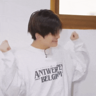 a young man wearing a white sweatshirt that says antwerp belgium on it