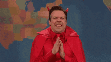 a man dressed as a devil with horns is praying with his hands folded .