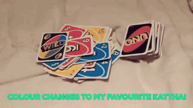 a man is holding a uno card in his mouth while sitting next to a woman