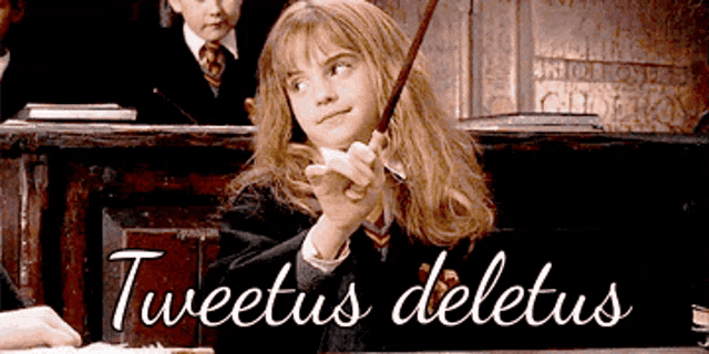 a girl in a harry potter costume is holding a wand in front of a sign that says tweetus deletus