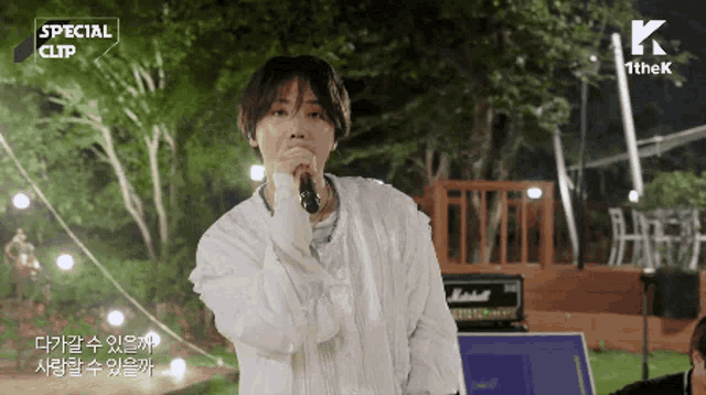 a young man is singing into a microphone with a special clip written above him