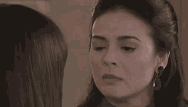 a close up of a woman looking at another woman 's face
