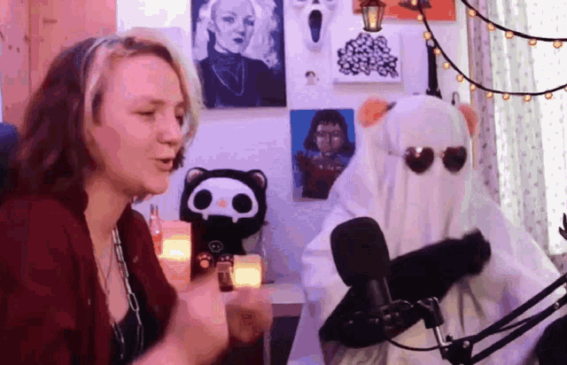 a woman and a ghost are talking in front of a microphone ..