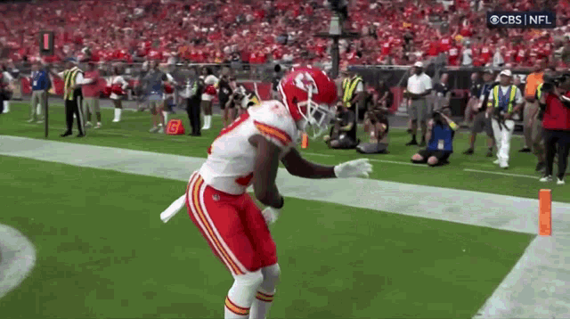 a football player in a chiefs uniform is running on the field .