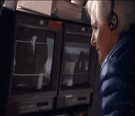 a man wearing headphones is looking at a tv screen