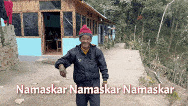 a man standing in front of a building with the name namaskar written on it