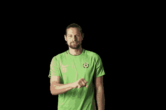a man in a green shirt with a soccer ball on it