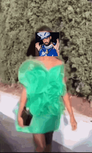 a woman in a green dress has a picture of drake in the background