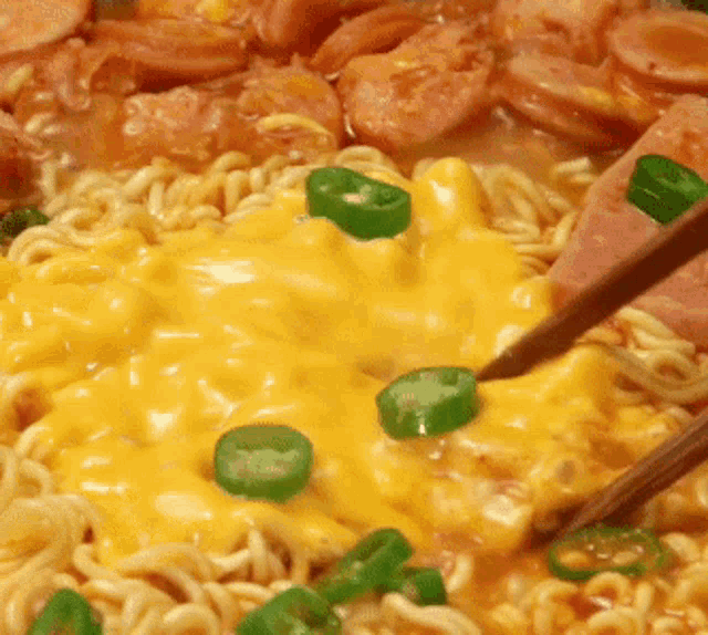 a bowl of noodles with cheese and green peppers on top