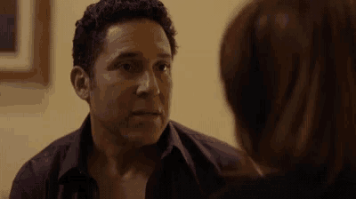 a man in a purple shirt is looking at a woman .