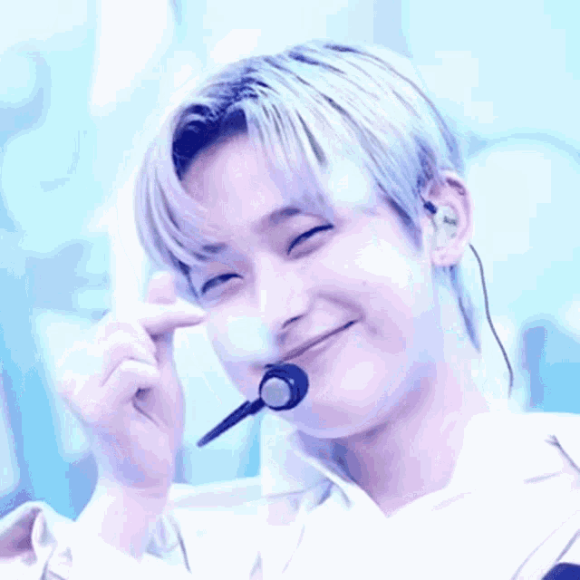 a young man wearing a microphone and headphones is smiling .