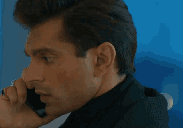 a close up of a man talking on a cellphone