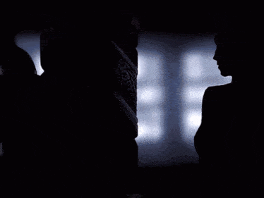 a blurred image of a person in a dark room with a light shining on their face