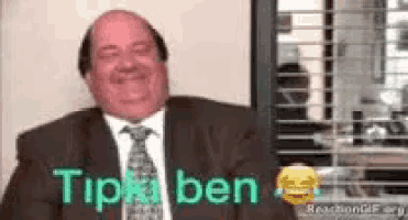 a man in a suit and tie is sitting in front of a window with the words `` tip ben '' written on it .