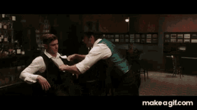 a man in a suit and tie is juggling a ball in a dark room ..