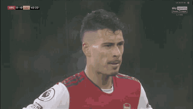 a soccer player wearing a red and white jersey with the word arsenal on the front