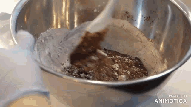 a person is mixing ingredients in a bowl with a spoon .