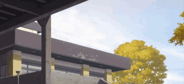 a building with a tree in the background and a blue sky in the background