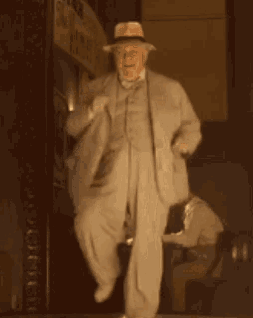 an older man in a suit and hat is dancing